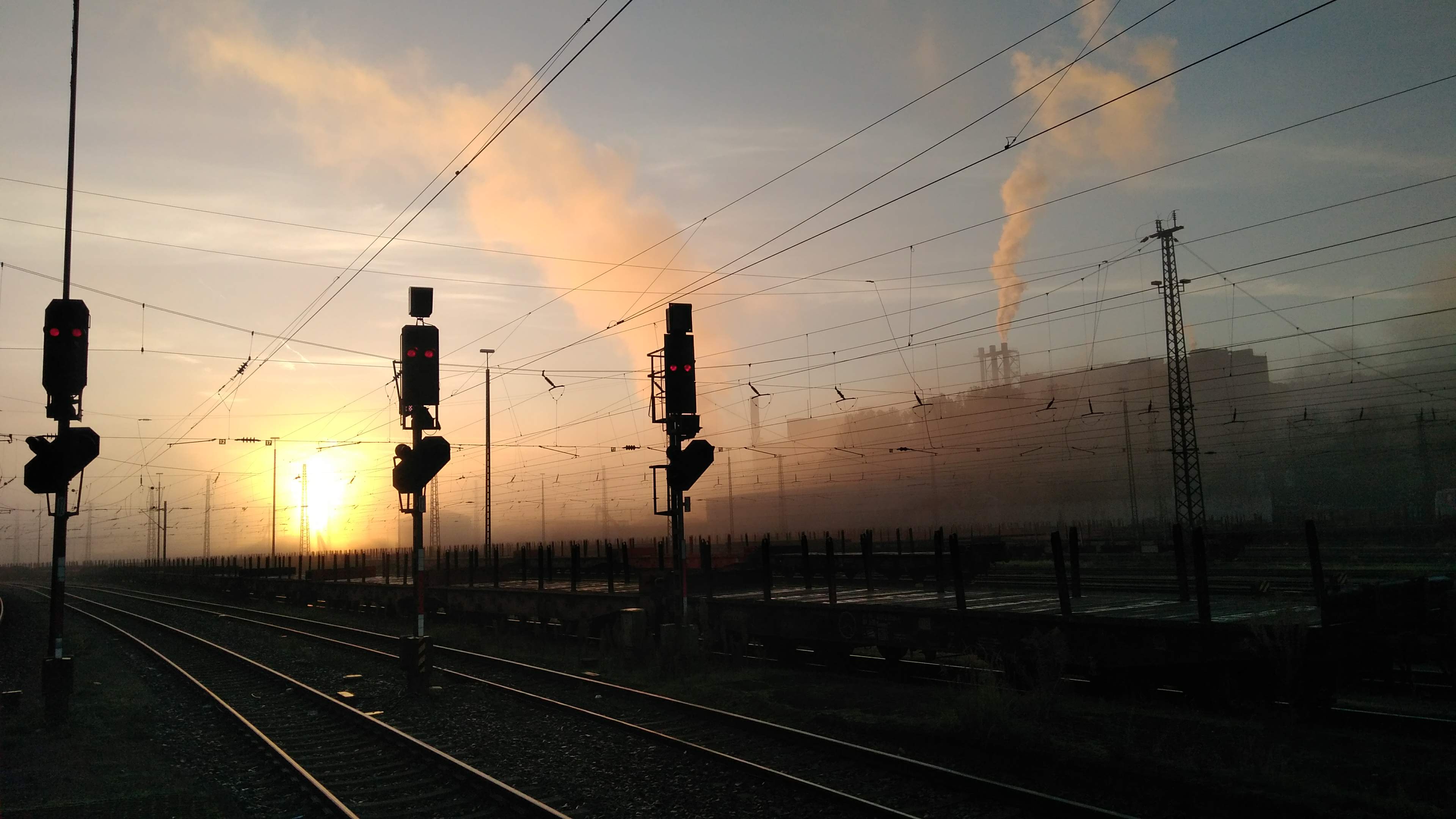 Ampelanlagen und Gleisbett bei Sonnenaufgang am Bahnhof in Völklingen.